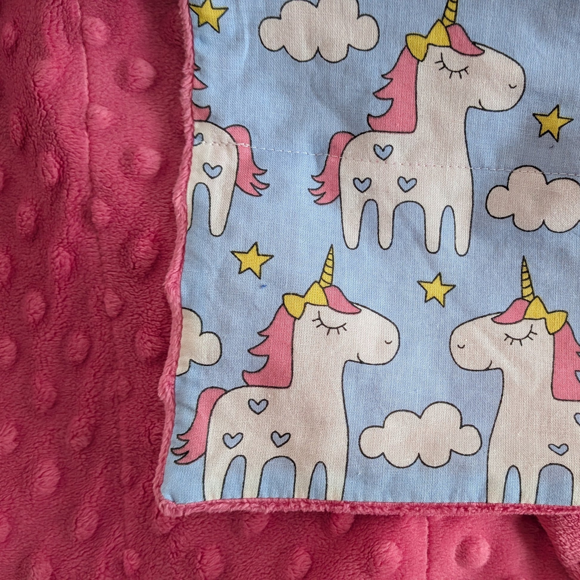 Children's weighted blanket with unicorn pattern on a blue background